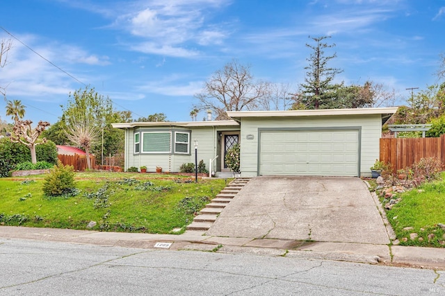 view of front of home featuring a garage, concrete driveway, a front yard, and fence