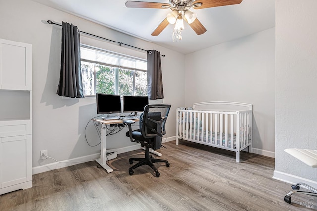 bedroom with a ceiling fan, baseboards, and wood finished floors