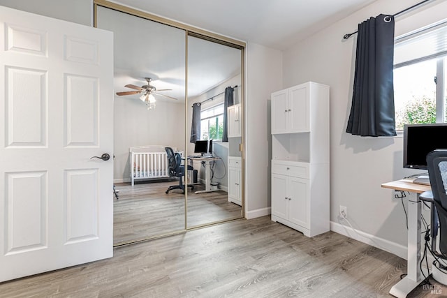 office with light wood-type flooring, baseboards, and a ceiling fan