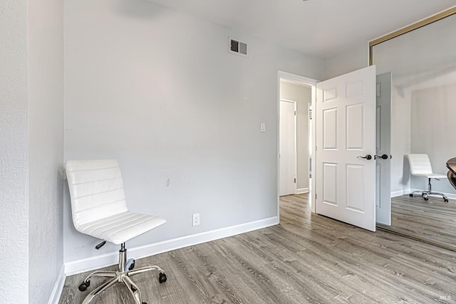 unfurnished office with light wood-style flooring, visible vents, and baseboards