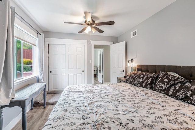 bedroom featuring ceiling fan, a closet, visible vents, and light wood-style floors