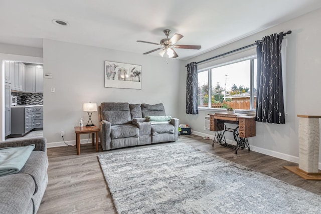 living area with ceiling fan, baseboards, and wood finished floors