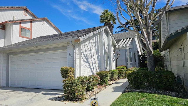 view of property exterior with an attached garage and concrete driveway