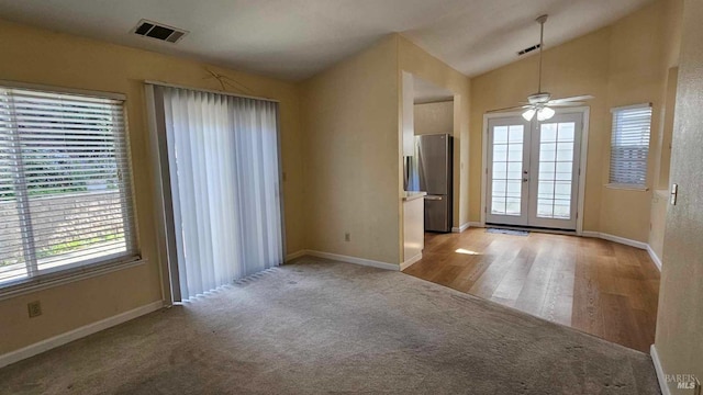 interior space with lofted ceiling, plenty of natural light, visible vents, and french doors