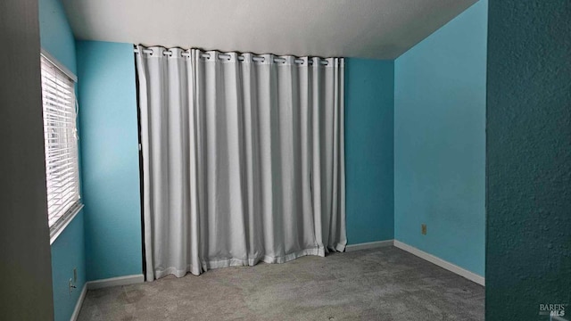 spare room with carpet and baseboards