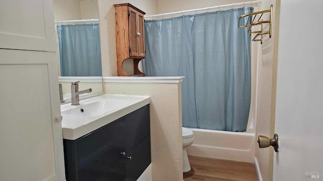 bathroom featuring toilet, vanity, wood finished floors, and shower / tub combo with curtain