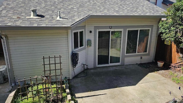 exterior space featuring a shingled roof, a patio area, and fence