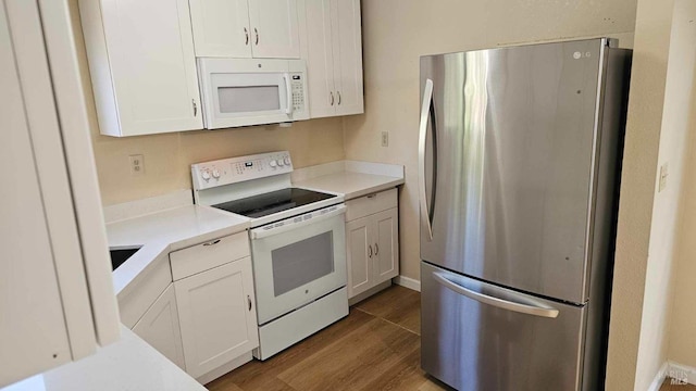 kitchen featuring white cabinets, white appliances, light countertops, and wood finished floors