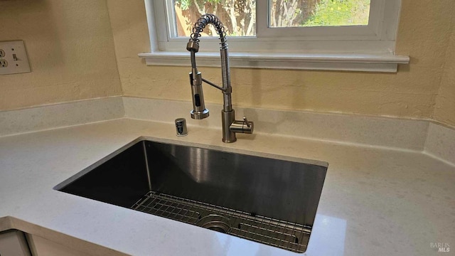 room details with a textured wall, light countertops, and a sink