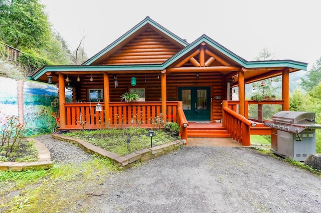 log cabin featuring french doors and a porch