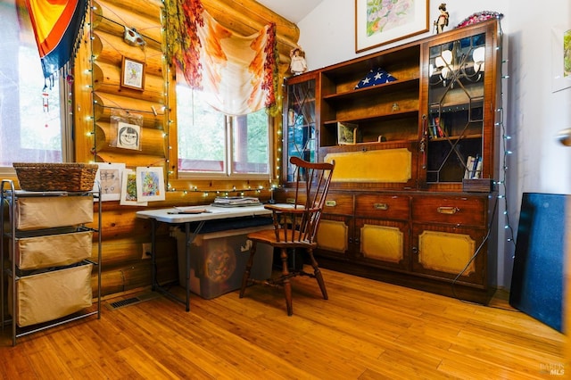 office featuring log walls and wood finished floors