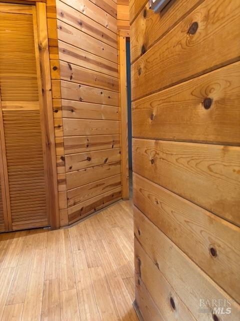 interior space featuring wood walls and light wood finished floors