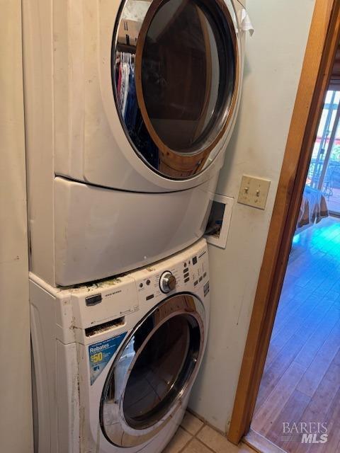 washroom featuring stacked washer / dryer and laundry area