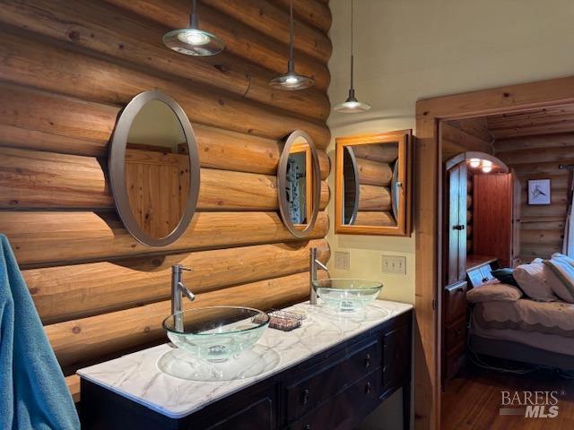 ensuite bathroom featuring ensuite bathroom, wood finished floors, and vanity