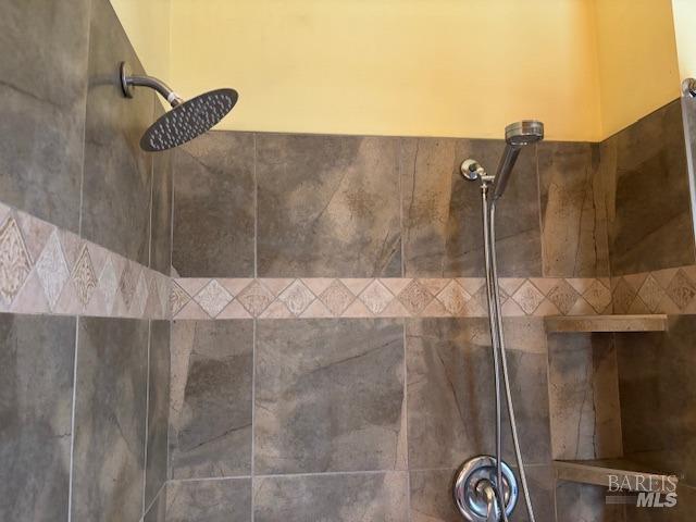 interior details featuring tiled shower