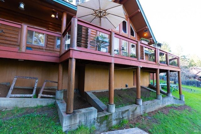 view of side of home featuring a lawn and a wooden deck