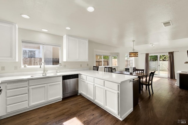 kitchen with visible vents, dishwasher, a peninsula, white cabinetry, and a sink