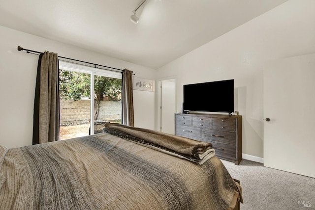 carpeted bedroom featuring lofted ceiling, baseboards, and track lighting