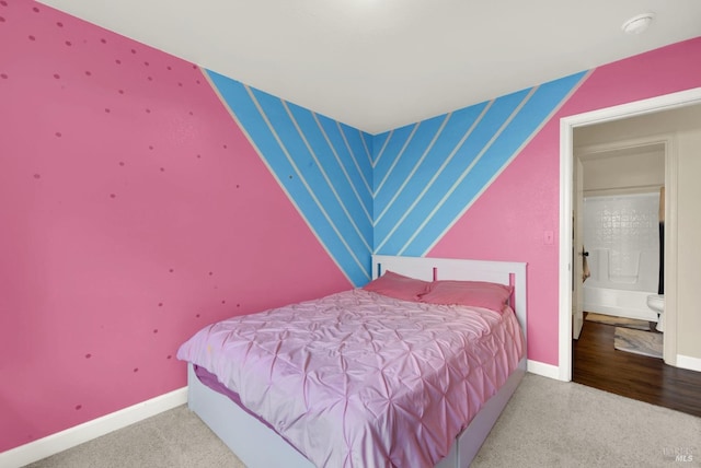 carpeted bedroom with wallpapered walls, an accent wall, and baseboards