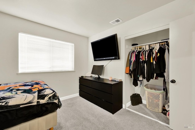 carpeted bedroom featuring a closet, visible vents, and baseboards