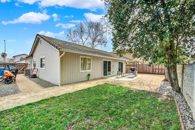 back of house with a patio area, a fenced backyard, and a lawn