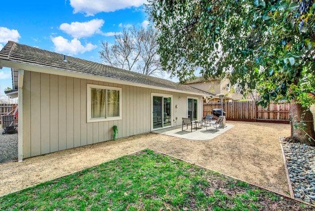 rear view of property featuring a fenced backyard and a patio