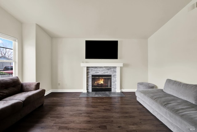 living room featuring a fireplace, dark wood finished floors, visible vents, and baseboards