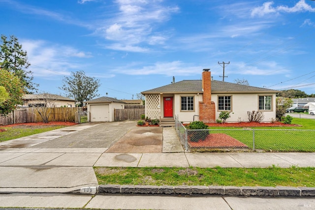 ranch-style home with a fenced front yard, an outbuilding, stucco siding, concrete driveway, and a front yard