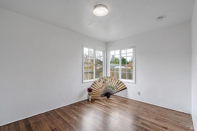 empty room with baseboards and wood finished floors