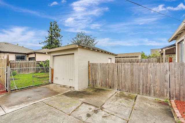 detached garage with a gate and fence