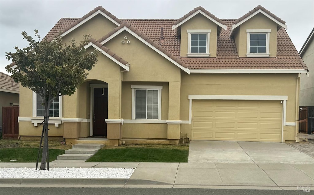 view of front of property with a tile roof, driveway, and stucco siding