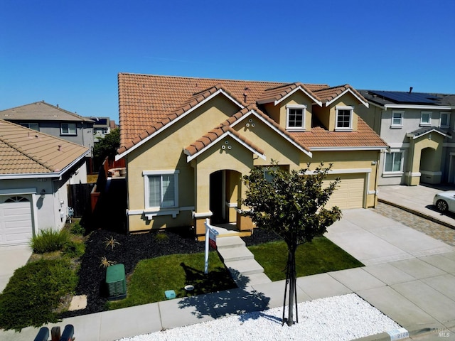 view of front of house with a garage, stucco siding, a tile roof, driveway, and a residential view
