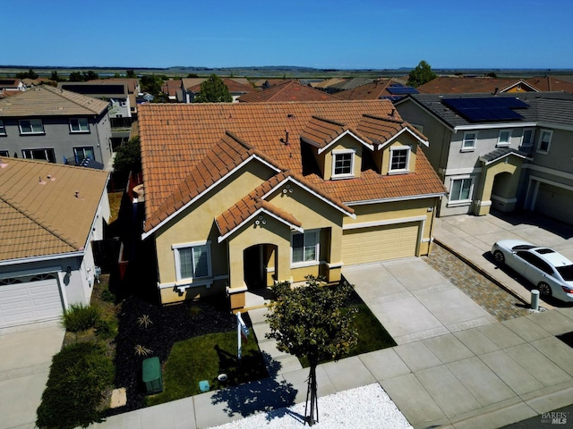 view of front facade featuring driveway, stucco siding, a residential view, and a tile roof