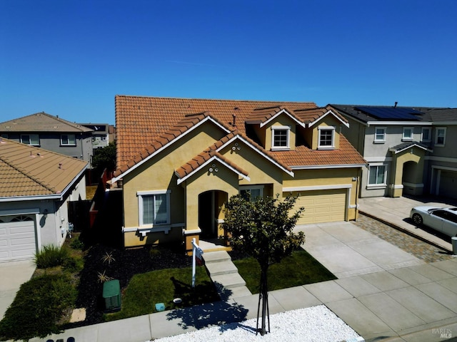 view of front of house featuring a tiled roof, stucco siding, a residential view, and concrete driveway