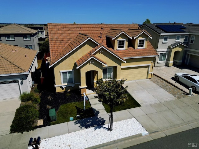 view of front of property with a tile roof, a garage, driveway, and stucco siding