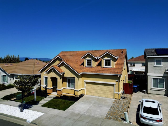 view of front of house featuring concrete driveway, stucco siding, an attached garage, and a tile roof