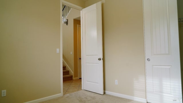 unfurnished bedroom with light colored carpet and baseboards