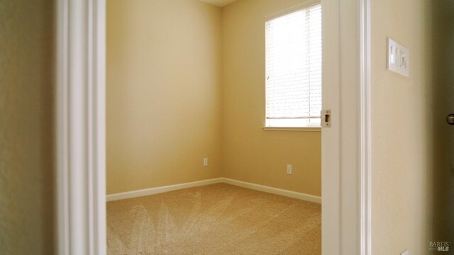 empty room with light colored carpet and baseboards