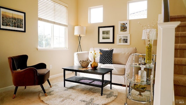 living area with stairway, baseboards, and carpet floors