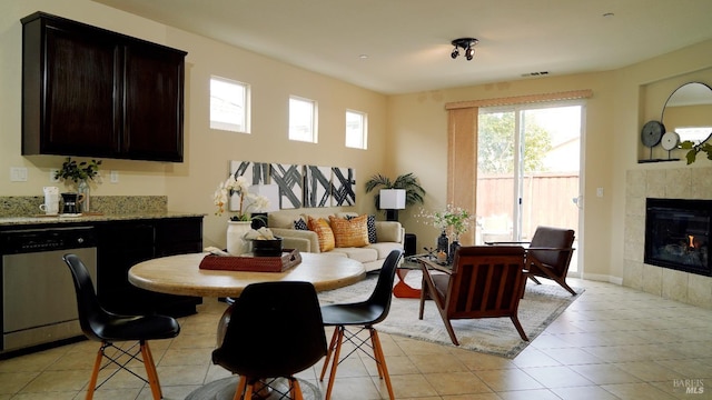 dining space featuring light tile patterned floors, visible vents, and a fireplace
