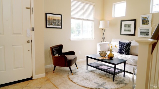living area featuring baseboards and light tile patterned flooring