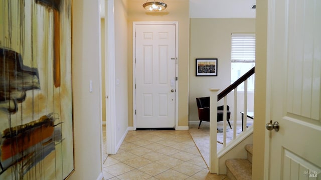 entrance foyer featuring light tile patterned floors and stairway