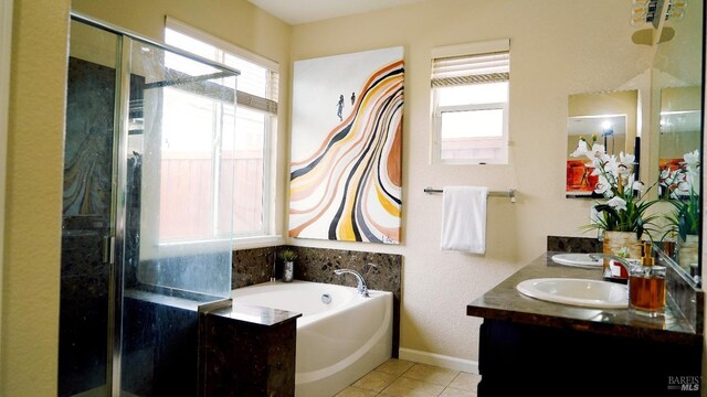 bathroom featuring a bath, a sink, double vanity, tile patterned floors, and a stall shower