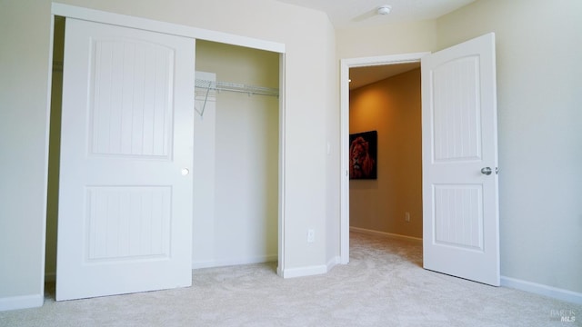 unfurnished bedroom with a closet, carpet flooring, and baseboards