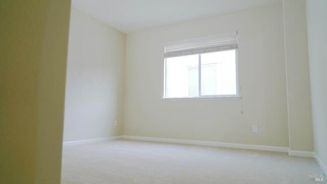 empty room with light carpet and baseboards