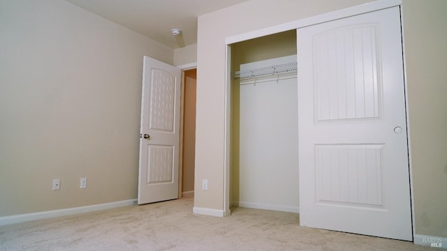 unfurnished bedroom featuring a closet, baseboards, and carpet