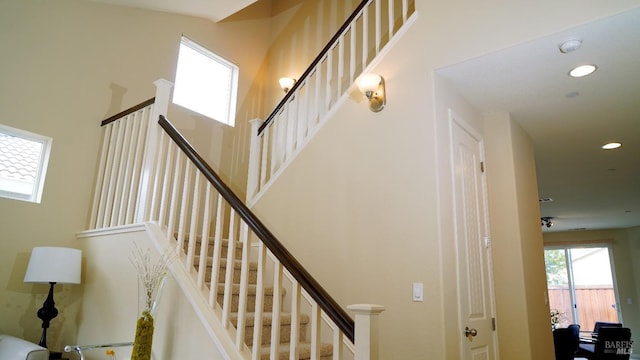 staircase with recessed lighting and a high ceiling