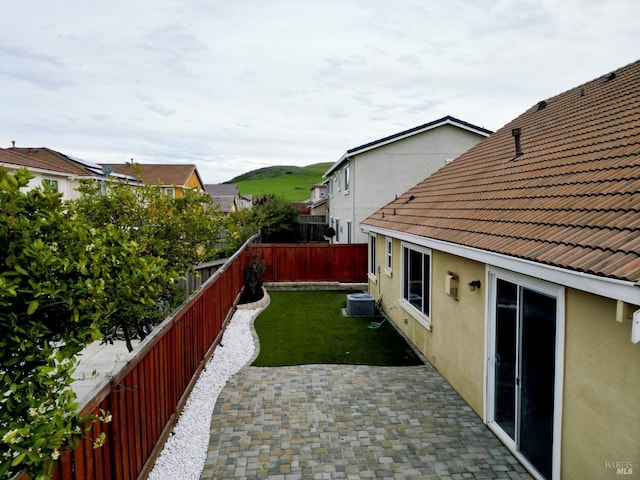 view of yard featuring a patio area, central air condition unit, and a fenced backyard