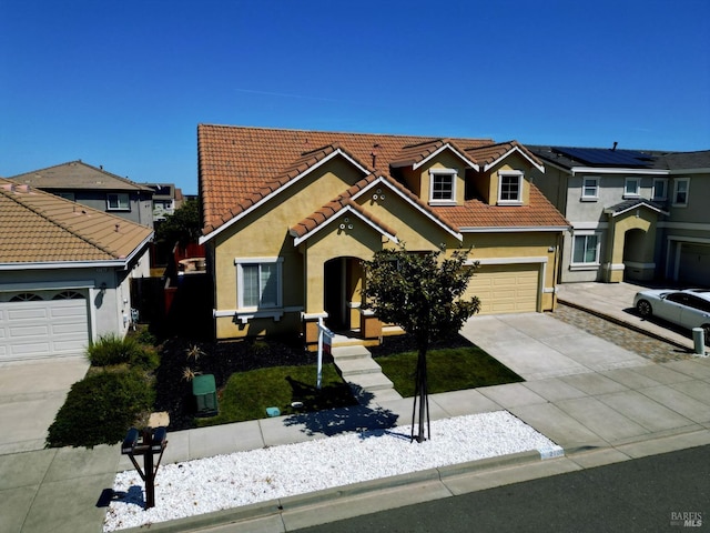 traditional-style house with concrete driveway, stucco siding, and a tile roof