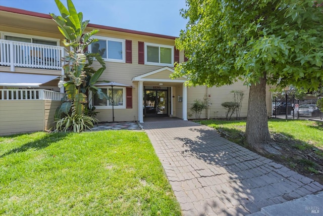 townhome / multi-family property with fence and a front yard